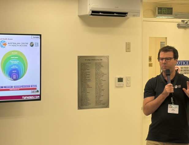 Man speaking into microphone explaining slide show presentation on TV
